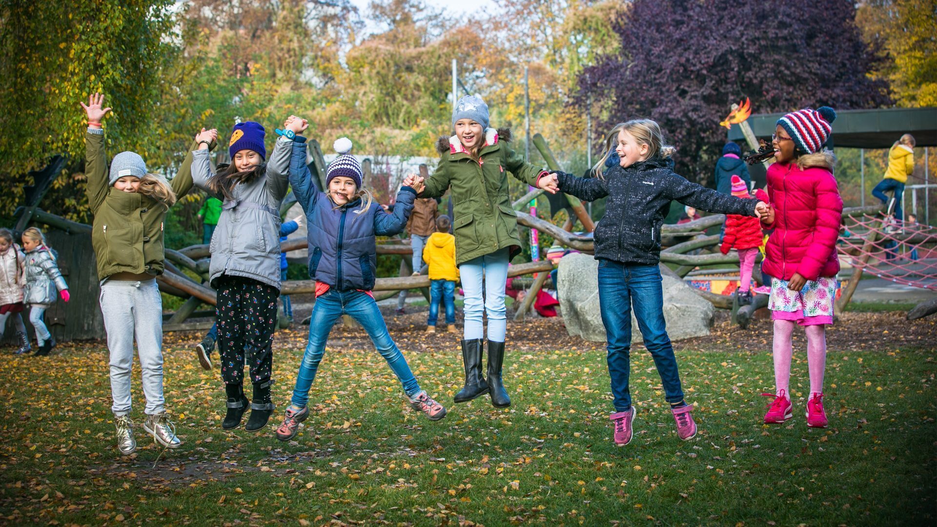 Kinder springen im Herbst auf dem Schulhof der St.-Michael-Grundschule Neu-Ulm