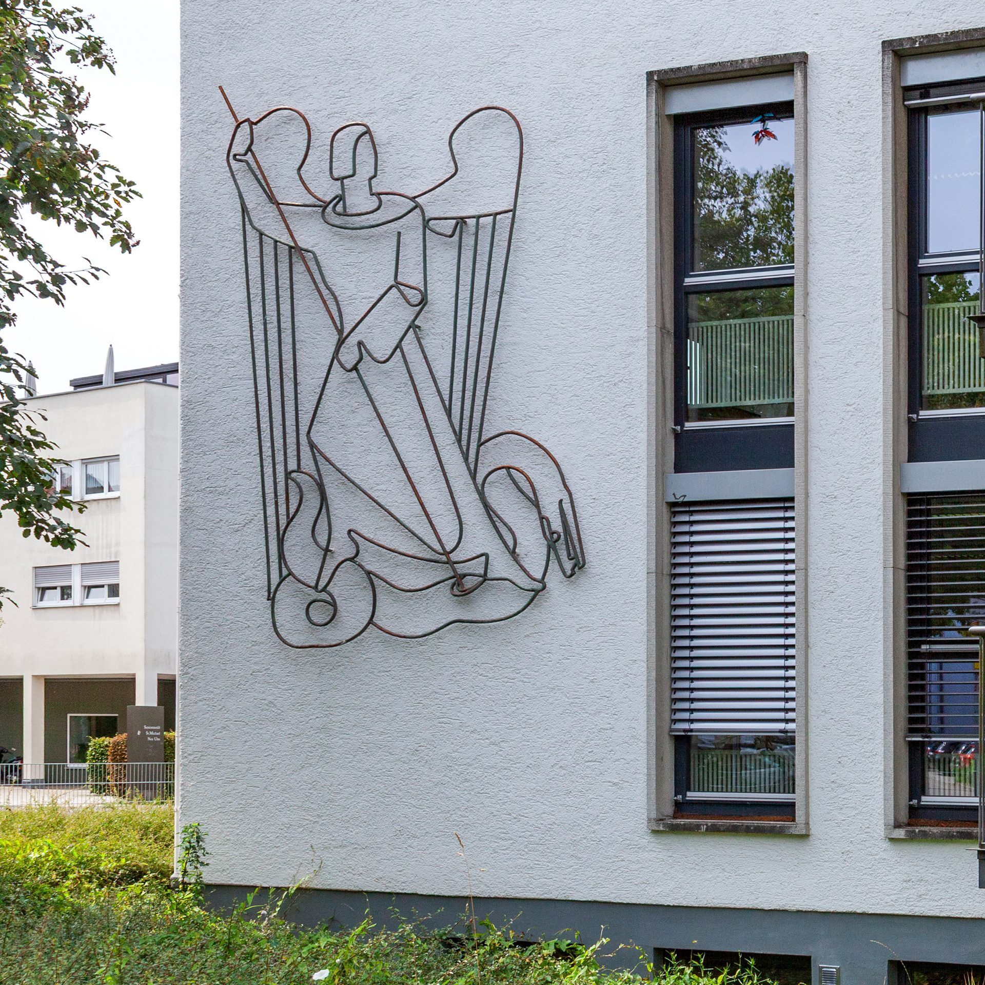 Metallrelief des Erzengels Michael an der Fassade der St.-Michael-Grundschule Neu-Ulm
