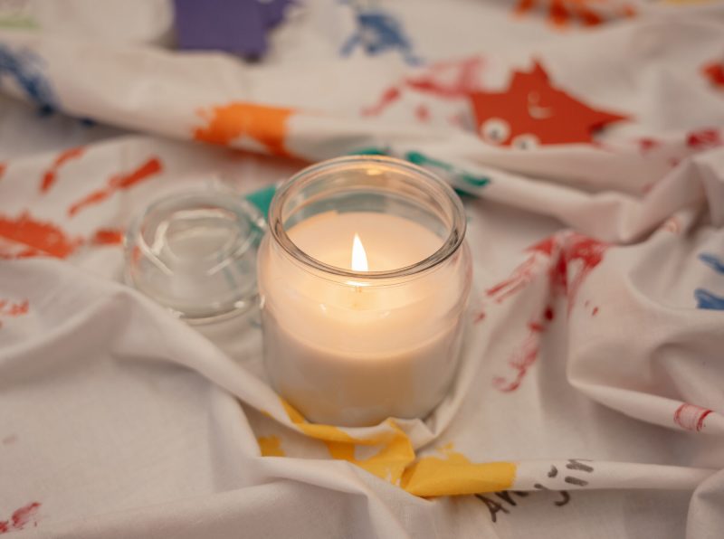 Brennende Jesuskerze im Glas auf einem bemalten Tuch im Morgenkreis der St.-Michael-Grundschule